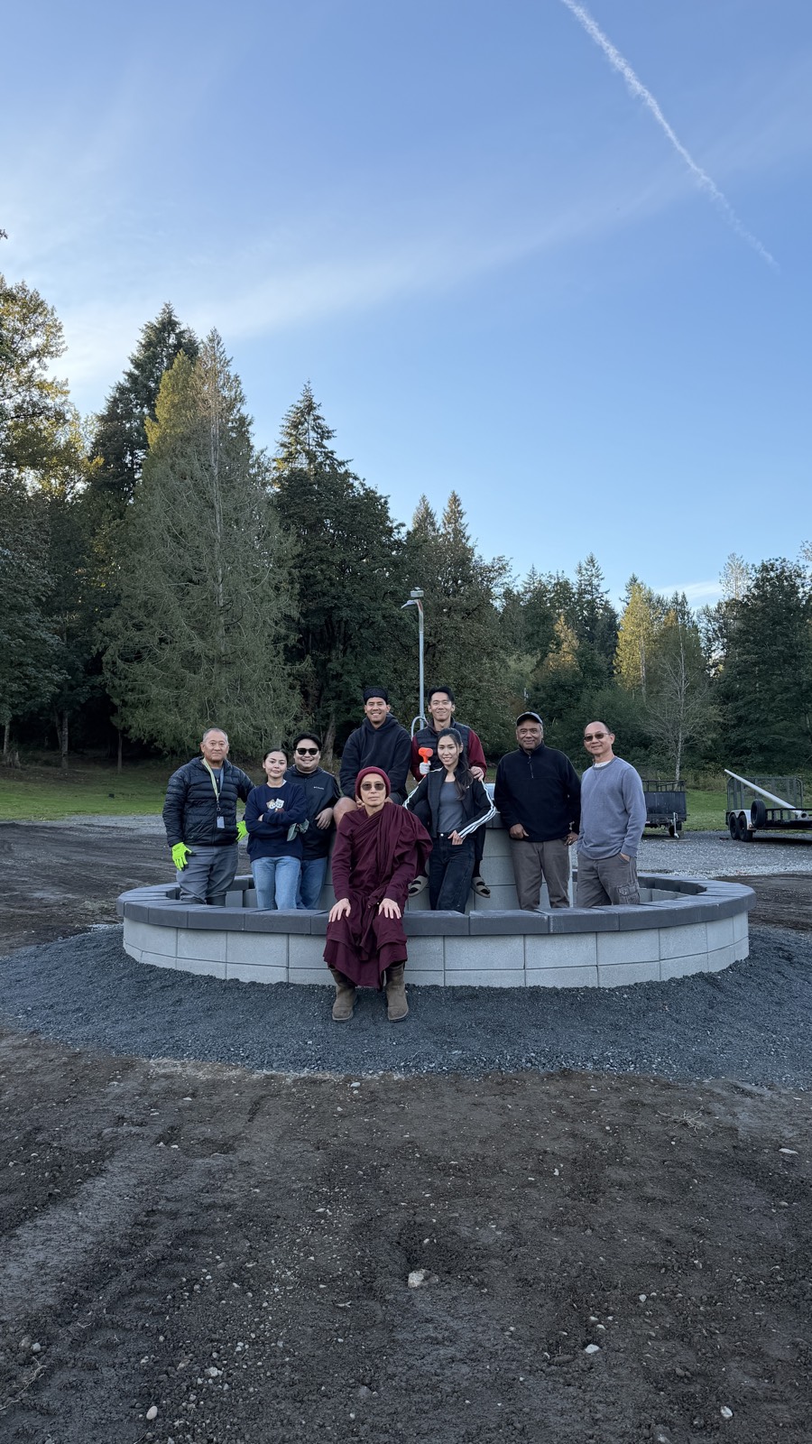 Volunteers and a monk gathered at the completed roundabout